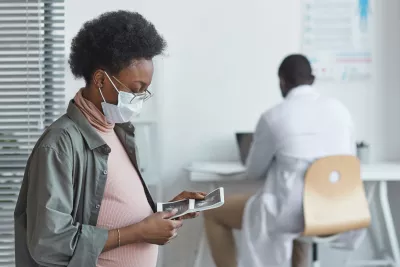 A pregnant woman looking at lab results in her doctor's office