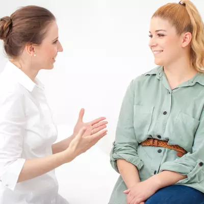Woman discussing ongoing stomach pain with her doctor