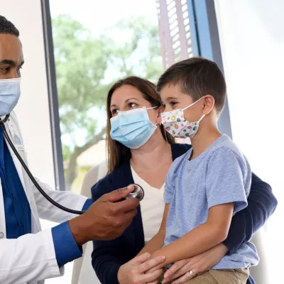 A doctor treating a mother and son.