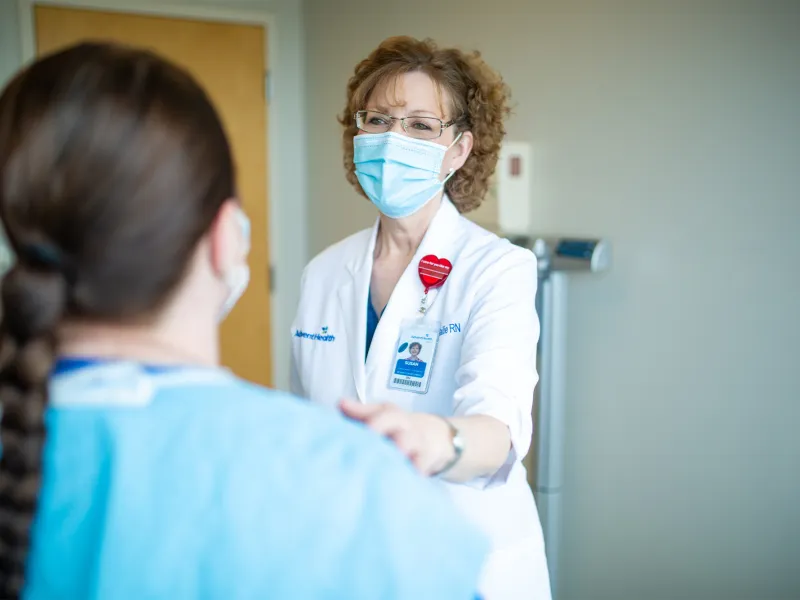 Susan Bailie, RN with her hand on a patient