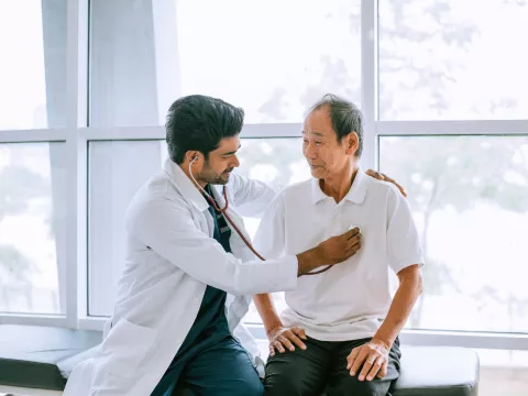 A Physician Listens to His Patients Heart with a Stethoscope