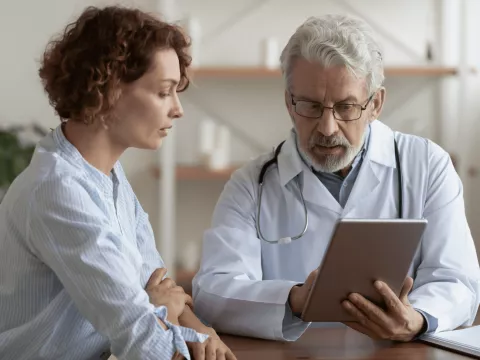 A Provider Goes Over a Patient's Chart with Her on a Tablet.