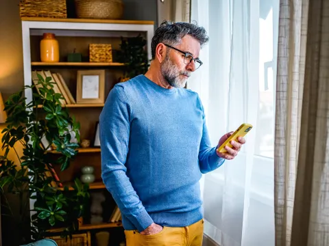 A middle-aged man reading info on his phone.