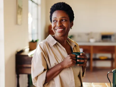 Woman smiling holding a cup of coffee