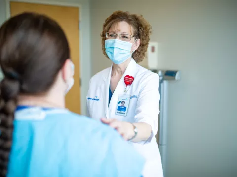 Susan Bailie, RN with her hand on a patient