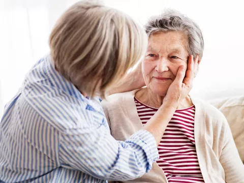 A daughter checks her mother for signs of a stroke.