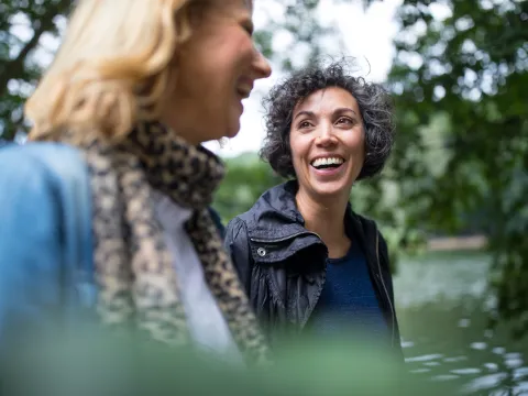 Two smiling women walking outdoors.