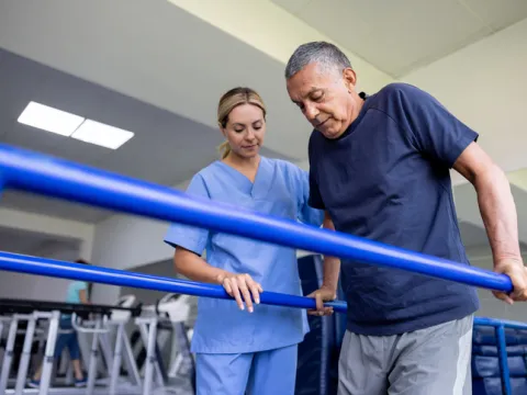 Man doing physical therapy and walking on bars