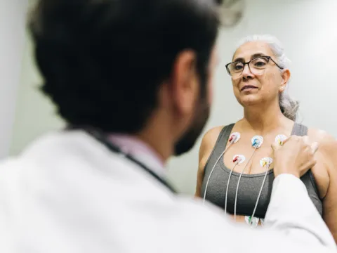 Patient talking with her doctor during a cardiopulmonary stress test on a hospital - stock photo