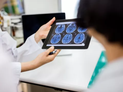 A hospital care team reviews scans of a patient's brain