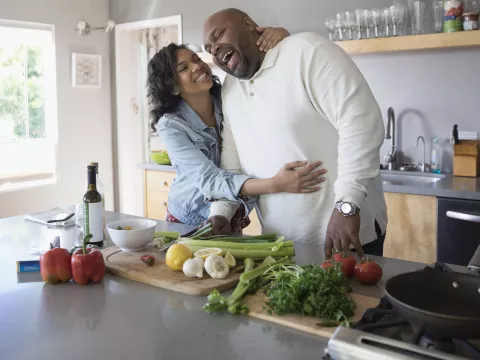 A father and daughter having fun while cooking a healthy meal together.