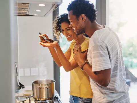 A young couple cooking in their kitchen at home.