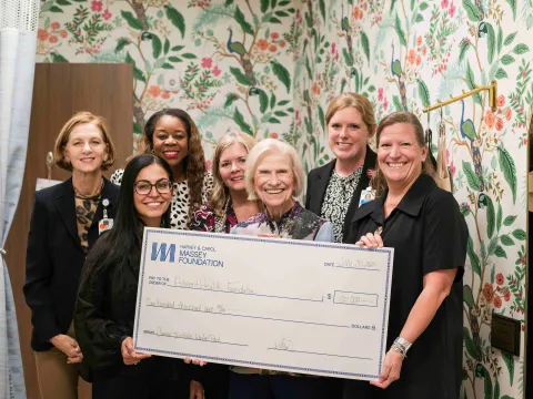 Andrea, Carol Massey and staff of the Winter Park Cancer Institute hold a large check.