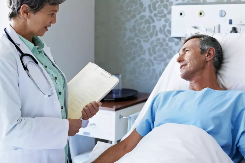 Doctor speaks to a patient who is lying in a hospital bed