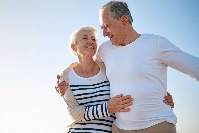 A couple walks on the beach after a successful hernia surgery.