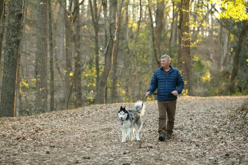Mark and his dog walking in the woods