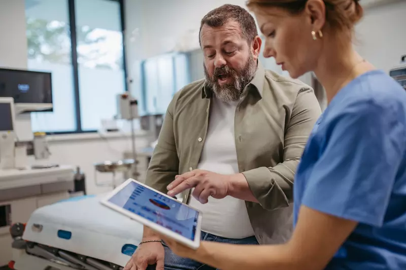 A male patient talks with a female doctor about his test results.