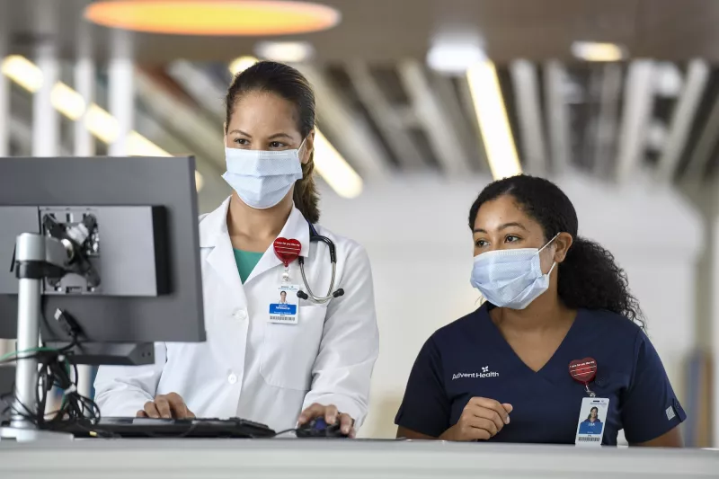 Two female physicians looking at a computer