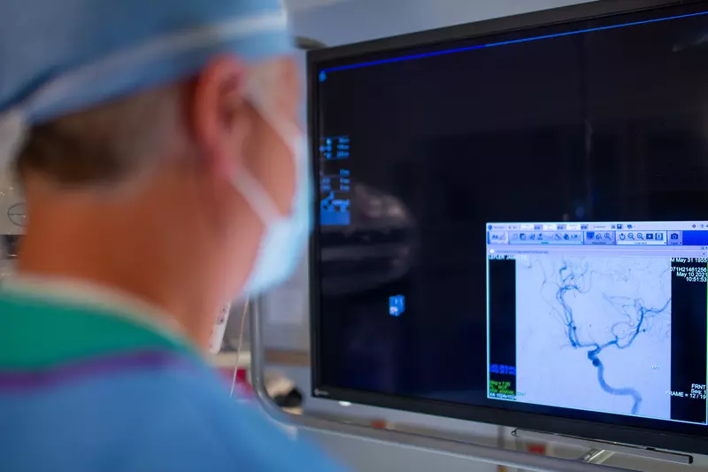 Neurointerventional radiologist using a C-ARM machine to perform a procedure.