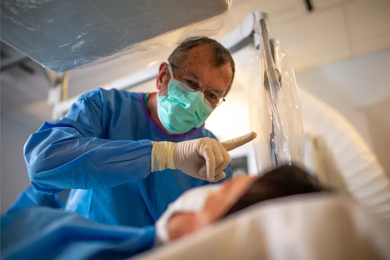 Neuro surgeon holding up a finger for a patient.