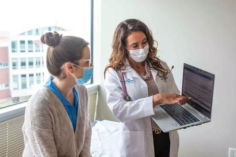 Physician showing a patient something on a laptop