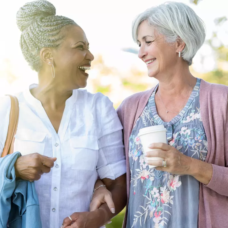 Two women walking and talking about their health.