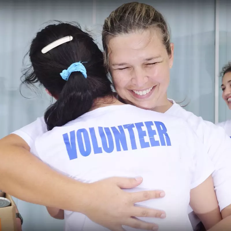 Young volunteers hugging.