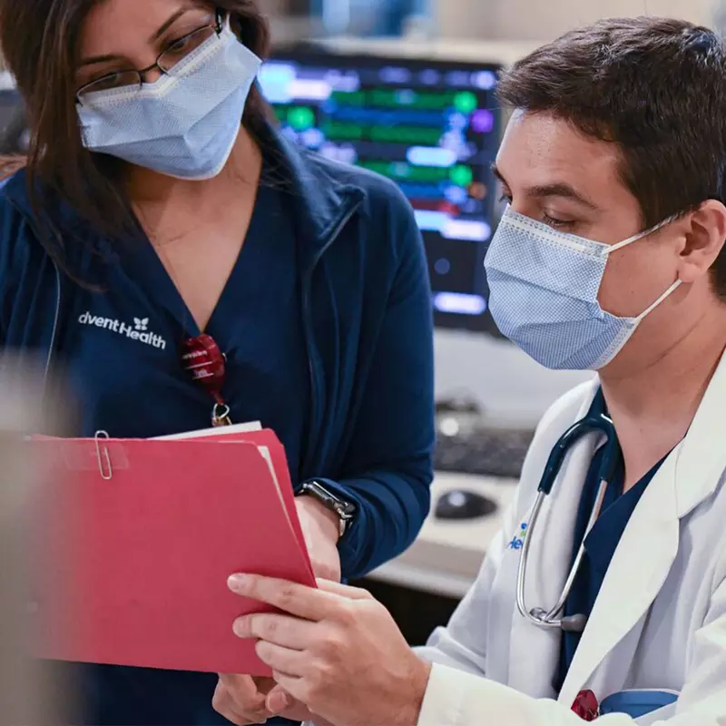 An Adventhealth physician and nurse going through a patient's file.