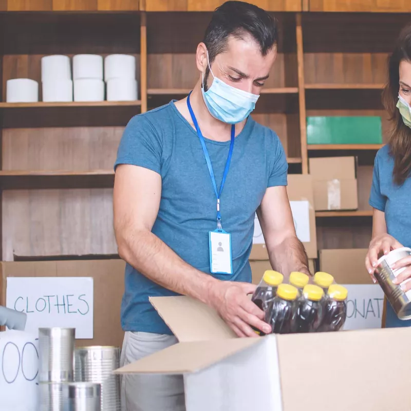 Two food drive volunteers wearing face masks.