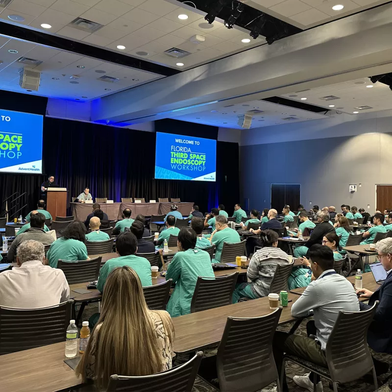 A room full of people watching a presentation.